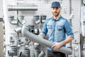 Plumber holding an extra large pipe